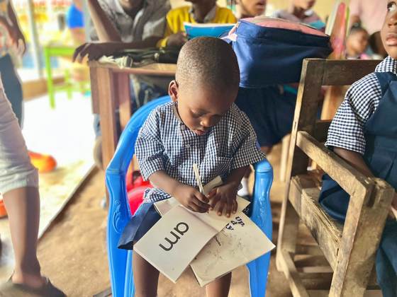 A young pupil works through reading flashcards