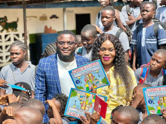 Fate and Kemah Tapson hand out reading books during a school visit